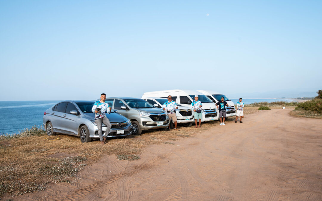 Local drivers stood by their vehicles in a row on the coast in Puerto Escondido